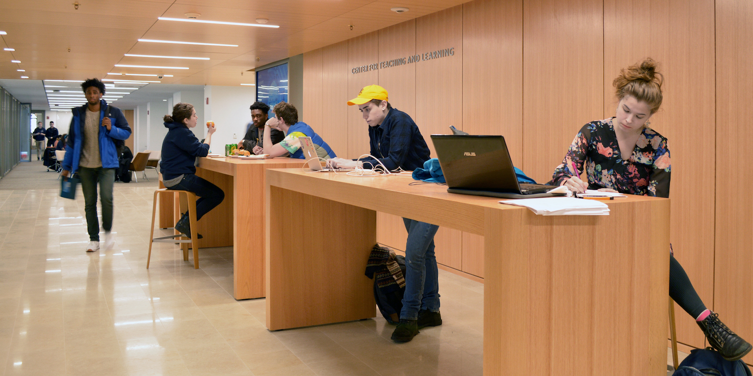  The Learning Commons in the Poorvu Center with a group of students working on the touchdown desks.